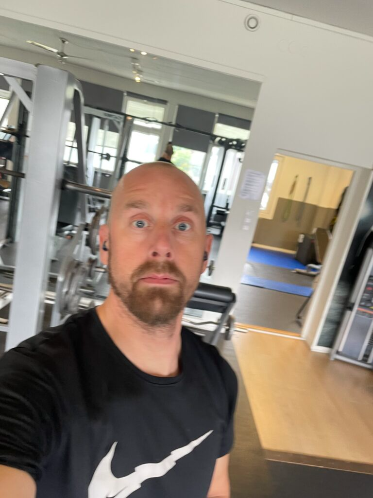 Person som tar en selfie i gymmiljö med spegeln bakom sig