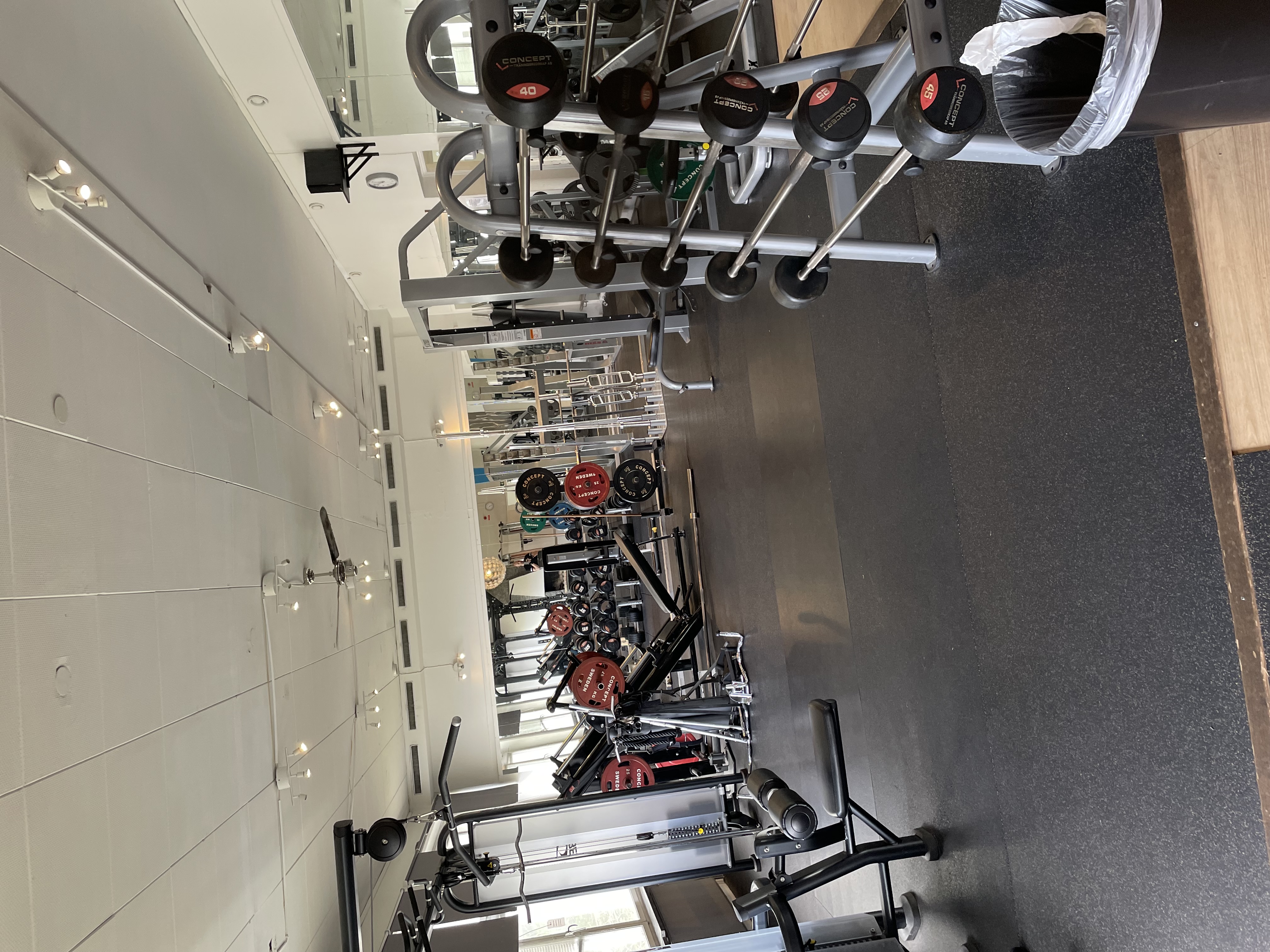 Gymmiljö med olika träningsmaskiner, skivstänger och hantlar – utrustning för effektiv styrketräning