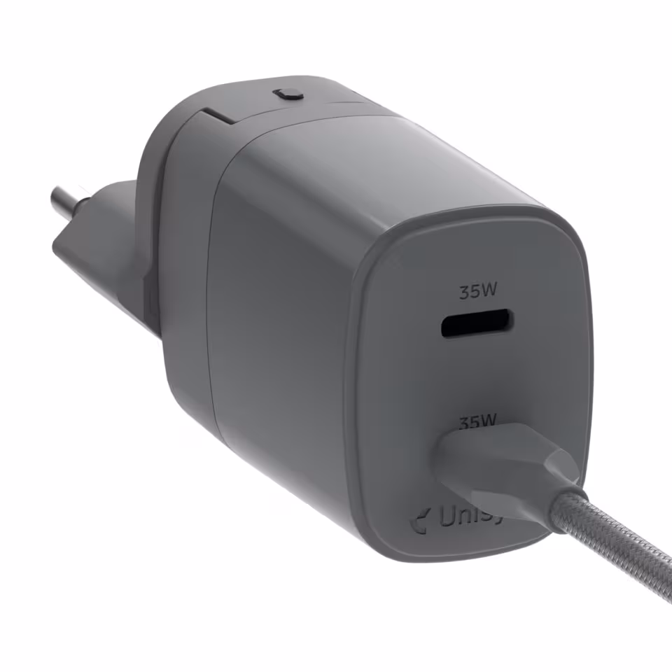 Unisynk kompakt USB-C-laddare med tvĂ„ portar och reseadaptrar â grĂ„ design mot vit bakgrund.
